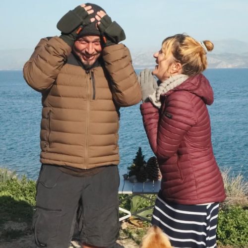 Alex und Kathy beim Überwintern in Griechenland mit dicken Jacken am Meer bei Sonnenschein