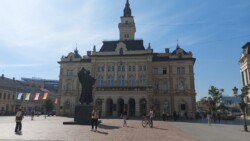 Kathy in Novi Sad Altstadt auf dem Marktplatz vor einem Denkmal