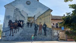 Kathy in Novi Sad bei Tag in der Fussgaengerzone großes Graffiti an Hauswand in der Altstadt